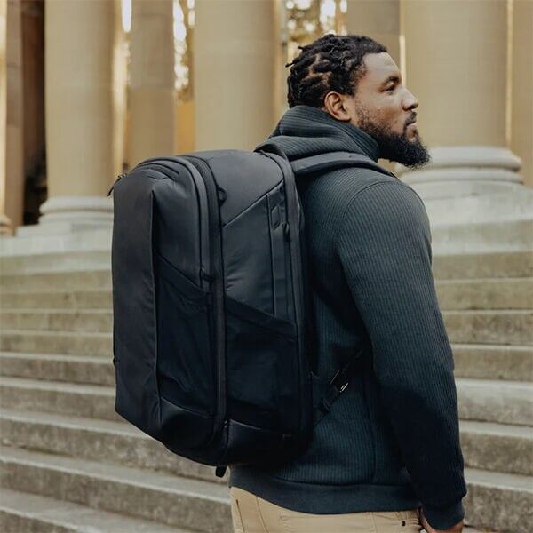 Peak Design Travel Backpack 2-in-1 in black, modular 40-liter travel backpack worn on the back by a person Peak Design Travel Backpack 2-in-1 in black, modular 40-liter travel backpack worn on the back by a person