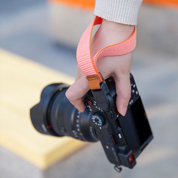 Haida camera wrist strap in orange, attached to the wrist